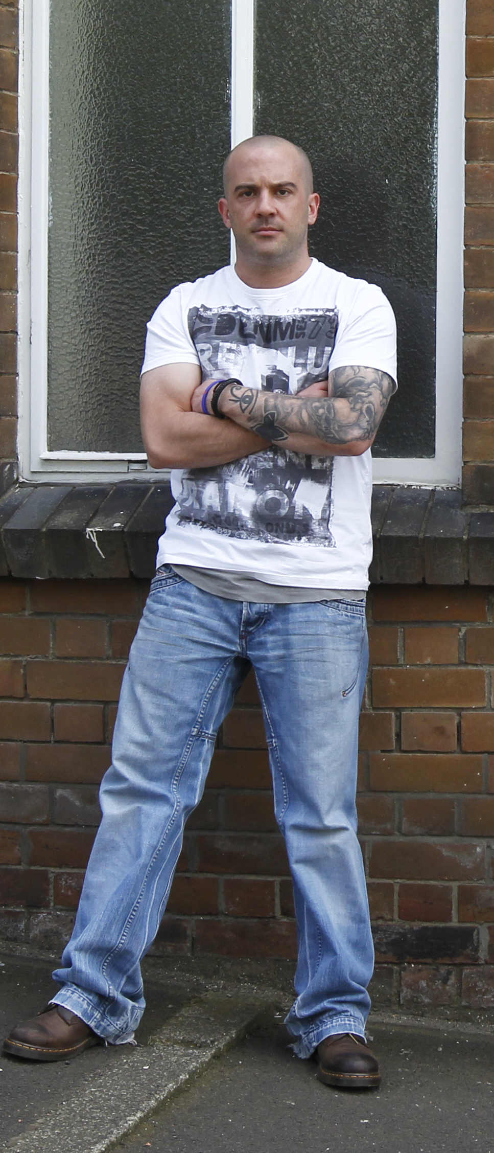 Portrait of Alex JM Hope standing with arms crossed